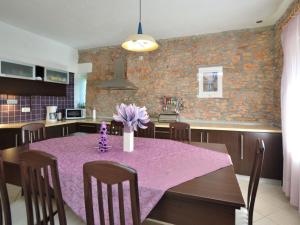eine Küche mit einem Tisch und einem lila Tischtuch in der Unterkunft Holiday Home Marija by Interhome in Bogatić