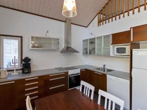 ユッラスヤルヴィにあるHoliday Home Halla by Interhomeのキッチン(木製キャビネット、テーブル、シンク付)