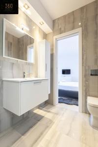łazienka z umywalką, toaletą i oknem w obiekcie Penthouse with BBQ Kitchen Island & Massive Living room by 360 Estates w mieście St. Julian’s