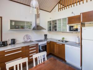 una cocina con electrodomésticos blancos y armarios de madera en Holiday Home Lauha by Interhome en Ylläsjärvi