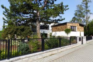 une clôture devant une maison avec un arbre dans l'établissement Villa Pinia, à Goczałkowice-Zdrój