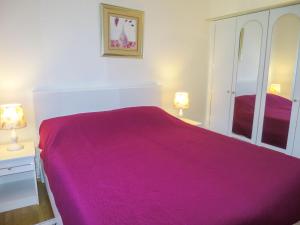ein Schlafzimmer mit einem lila Bett mit zwei Lampen in der Unterkunft Holiday Home Ive by Interhome in Petrcane