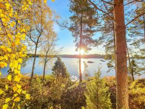 una vista de un lago con el sol brillando entre los árboles en Holiday Home Sointukallio by Interhome, en Savonlinna