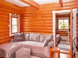 uma sala de estar com um sofá numa cabana de madeira em Holiday Home Tahkon nipashonka 2 a by Interhome em Tahkovuori