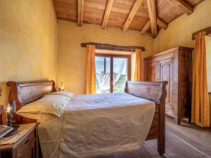 ein Schlafzimmer mit einem großen Bett und einem Fenster in der Unterkunft Apartment Giallo by Interhome in Cortemilia