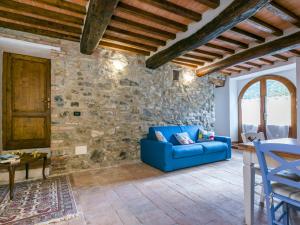 a living room with a blue couch and a stone wall at Apartment Irene by Interhome in Torre SantʼAlluccia