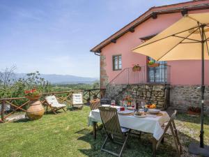 a table with an umbrella in the yard of a house at Holiday Home Le Poggiole-1 by Interhome in Cavriglia