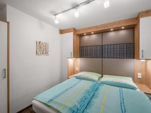 a bedroom with a large bed with blue sheets at Apartment Hinterreit-2 by Interhome in Maria Alm am Steinernen Meer