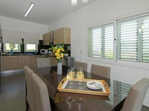 a dining room with a table with chairs and a kitchen at Villa palm by Interhome in Protaras