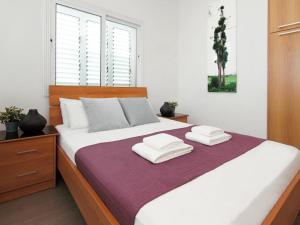 a bedroom with a large bed with towels on it at Villa palm by Interhome in Protaras
