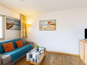 ein Wohnzimmer mit einem blauen Sofa und einem Tisch in der Unterkunft Apartment Les Platanes-4 by Interhome in Sainte-Maxime