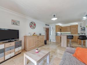 a living room with a couch and a tv and a kitchen at Apartment Le Domaine de la Baie-3 by Interhome in Cavalaire-sur-Mer