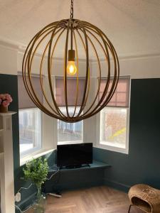 una gran lámpara de araña en una sala de estar con ordenador en Frasers Apartment, en Golspie