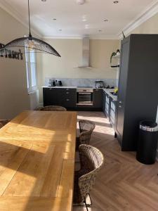 - une cuisine avec une table en bois et des chaises dans l'établissement Frasers Apartment, à Golspie