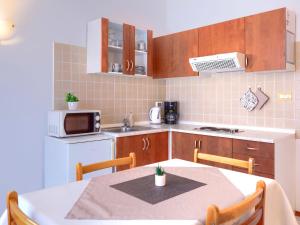 a kitchen with a table and a kitchen with a microwave at Apartment Bruno-1 by Interhome in Umag