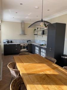 uma cozinha com uma mesa de madeira e cadeiras em Frasers Apartment em Golspie