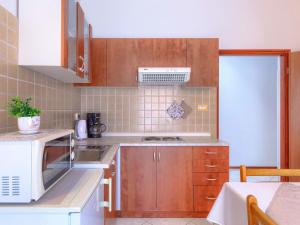 a kitchen with wooden cabinets and a stove top oven at Apartment Bruno-1 by Interhome in Umag