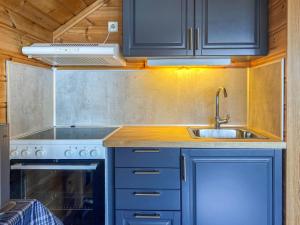 uma cozinha com um lavatório e um fogão em Chalet Hardangerrorbu - FJH411 by Interhome em Tjoflot