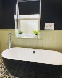 a bath tub in a bathroom with a window at Frasers Apartment in Golspie +15 photos