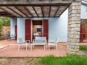 リオ・マリーナにあるHoliday Home Villaggio Mezzo Ortano-1 by Interhomeのパティオ(日よけの下にテーブルと椅子付)