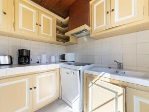 ノヴにあるHoliday Home Mas Madelon by Interhomeの白いキャビネットと白い食器洗い機付きのキッチンが備わります。