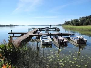 Chalet Lindby Pärlan - STH150 by Interhome في Adelsö: ترسو ثلاث قوارب في مرسى على البحيرة