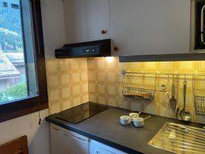 a kitchen with yellow tile on the wall at Studio Champraz-14 by Interhome in Chamonix