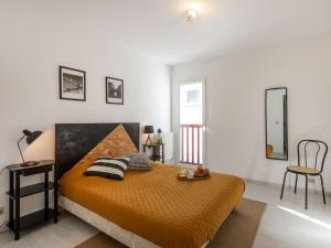 a bedroom with a bed with an orange blanket at Apartment Ederra Untxin by Interhome in Socoa