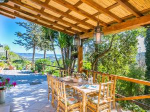 a patio with a table and chairs under a wooden pergola at Holiday Home La Tordara by Interhome in Porto Santo Stefano