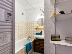 a bathroom with a tub and a sink at Studio Ariane-5 by Interhome in Le Corbier