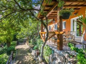 une maison avec une terrasse couverte dotée d'une table et de chaises dans l'établissement Holiday Home La Tordara by Interhome, à Porto Santo Stefano