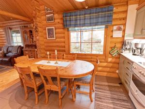 a kitchen and dining room with a wooden table and chairs at Holiday Home Tievanlaita 10 by Interhome in Äkäslompolo
