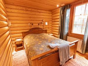 a bedroom with a bed in a log cabin at Holiday Home Tievanlaita 10 by Interhome in Äkäslompolo