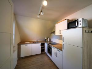 a kitchen with white cabinets and a white refrigerator at Apartment Müritz Ferienpark Röbel-8 by Interhome in Röbel