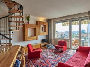 ein Wohnzimmer mit roten Stühlen und einer Treppe in der Unterkunft Apartment Isabella by Interhome in Consiglio di Rumo