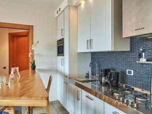 eine Küche mit weißen Schränken und einem Holztisch in der Unterkunft Apartment Isabella by Interhome in Consiglio di Rumo