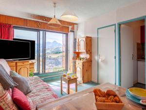 ein Wohnzimmer mit Couch und großem Fenster in der Unterkunft Apartment L'Edioule by Interhome in La Toussuire
