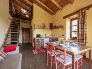 een keuken en eetkamer met een houten tafel en stoelen bij Apartment Rosso by Interhome in Cortemilia