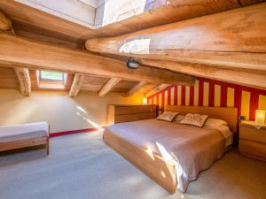 een slaapkamer met een groot bed en houten plafonds bij Apartment Rosso by Interhome in Cortemilia