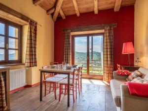 een woonkamer met een tafel en een bank bij Apartment Rosso by Interhome in Cortemilia