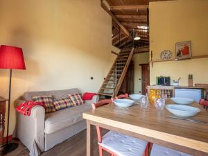 een woonkamer met een tafel en een bank bij Apartment Rosso by Interhome in Cortemilia
