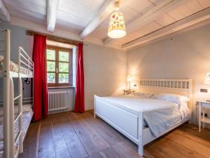 Un dormitorio con una cama blanca y cortinas rojas. en Apartment Azzuro by Interhome, en Cortemilia