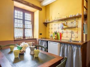 cocina con mesa de madera y paredes amarillas en Apartment Azzuro by Interhome, en Cortemilia