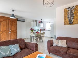 sala de estar con 2 sofás marrones y cocina en Holiday Home A la porte d'Avignon by Interhome, en Laudun