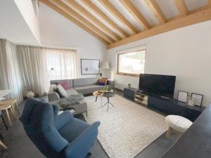 a living room with a blue couch and a tv at Apartment Raber by Interhome in Churwalden