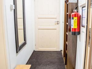 a fire extinguisher on the wall next to a door at Holiday Home Levinkolmio c5 by Interhome in Sirkka