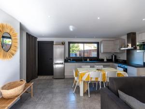 a kitchen and living room with a table and chairs at Holiday Home St Cyprien Plage by Interhome in San Ciprianu