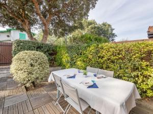 a table with a white table cloth on a patio at Holiday Home lotissement Les Rives de Capbreton by Interhome in Capbreton