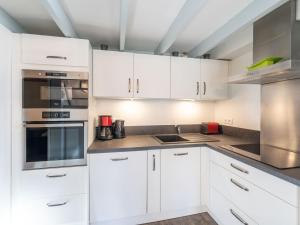 a kitchen with white cabinets and stainless steel appliances at Holiday Home lotissement Les Rives de Capbreton by Interhome in Capbreton