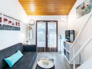 a living room with a couch and a tv at Holiday Home lotissement Les Rives de Capbreton by Interhome in Capbreton